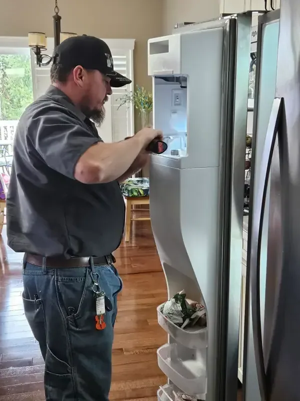 Mid America Service technician repairing a refrigerator ice maker in St. Peters, Missouri