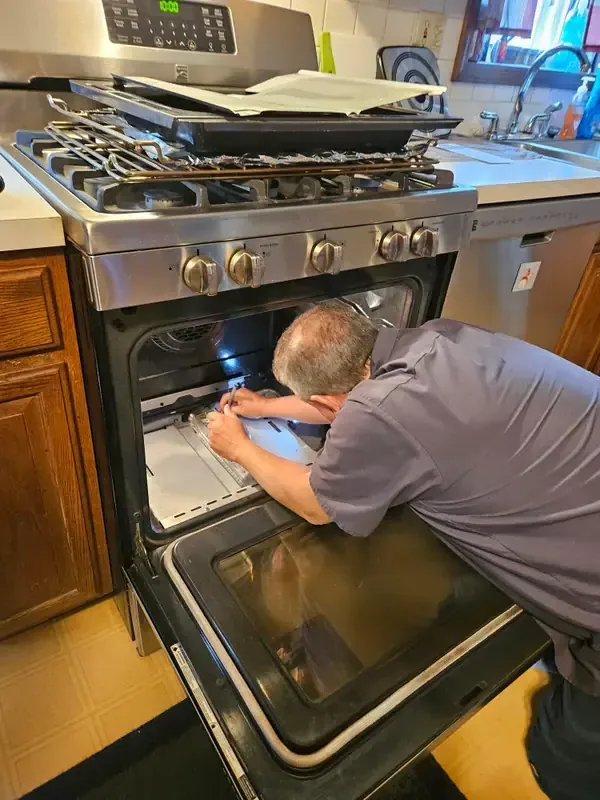 Mid America Service technician repairing a range oven in St. Peters, Missouri